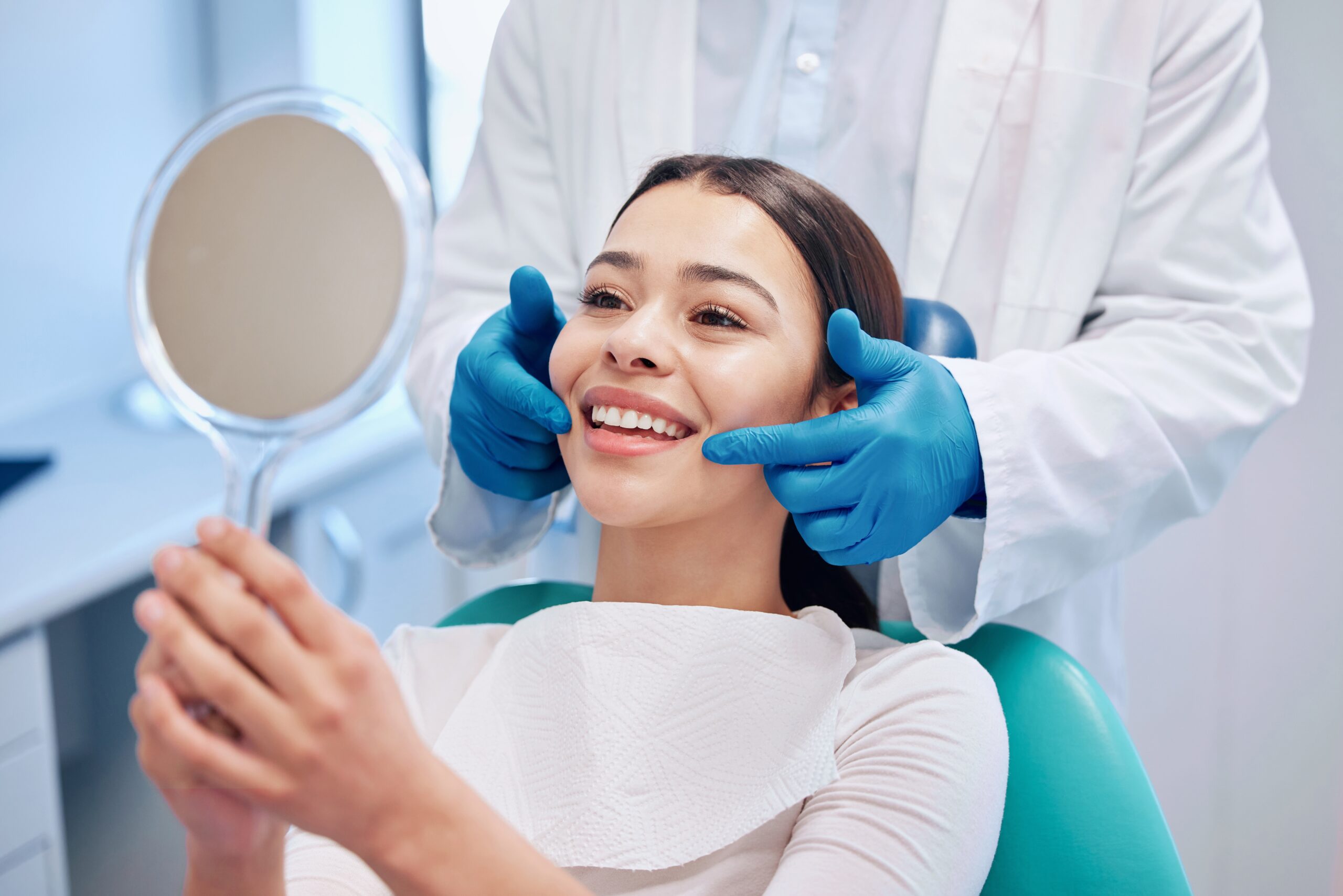 A patient's happy smile reflects in the mirror, guided by their Periodontist in Los Angeles.