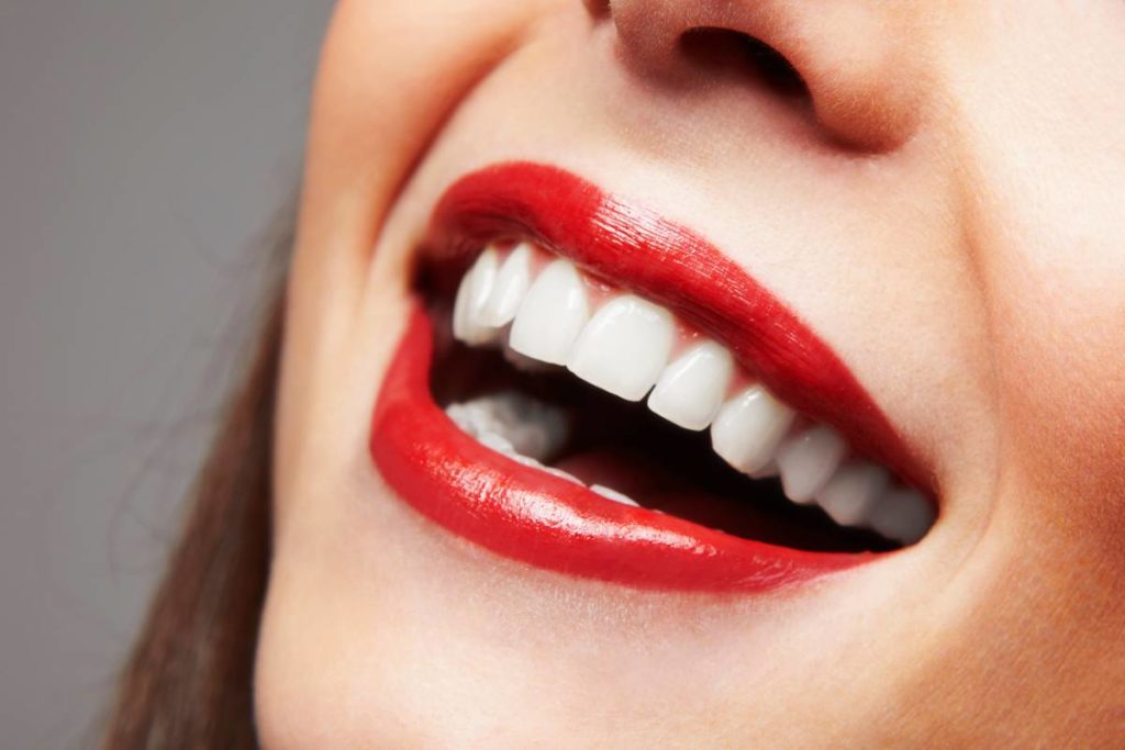 woman with lipstick smiling showing white teeth