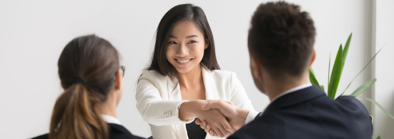 Smiling asian female vacancy candidate shaking hand with hr manager